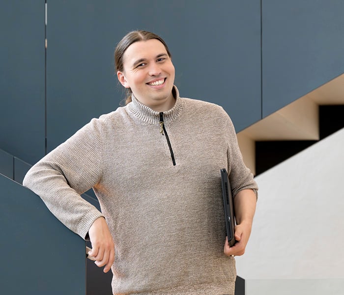 KSP Person smiling at the camera holding a laptop 700x600